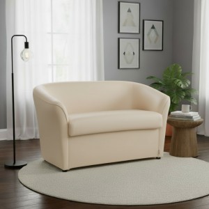 Vista ambientata di un divano 2 posti di design a pozzetto artigianale fatto in italia con solida struttura in legno ed ecopelle colore beige anti macchia lavabile Totò Piccinni