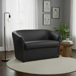 Vista ambientata di un divano 2 posti di design a pozzetto artigianale fatto in italia con solida struttura in legno ed ecopelle colore nero anti macchia lavabile Totò Piccinni