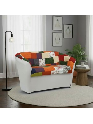 Vista ambientata di un divano 2 posti di design a pozzetto artigianale fatto in italia con solida struttura in legno ed ecopelle colore bianco e tessuto patchwork anti macchia lavabile Totò Piccinni