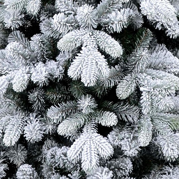Floccatura fiocchi di neve bianchi su rami e rametti verdi in un albero di Natale realistico stretto Innevato Cervino Slim Xone
