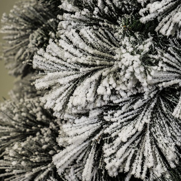 Rami e foglie verdi coperti da floccatura neve artificiale effetto realistico di un albero di natale foltissimo innevato Carey Xone 